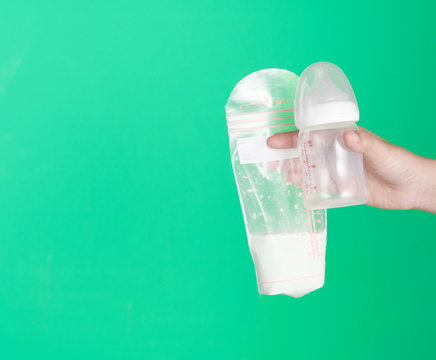 Mother Holding Breast Milk Storage Bag For Baby On Green Background