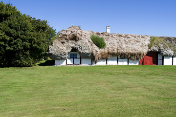 Fototapeta na wymiar Laesoe / Denmark: Old half-timbered farmhouse thatched with a seaweed roof