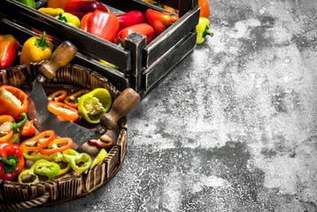 chopped sweet pepper in a wooden tray with a knife.