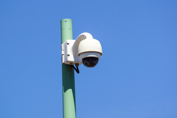 High tech overhead security camera with a blue sky