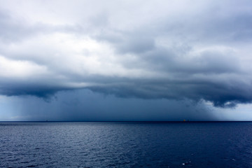 Fototapeta na wymiar Daek blue sea color and storm raining cloud background.