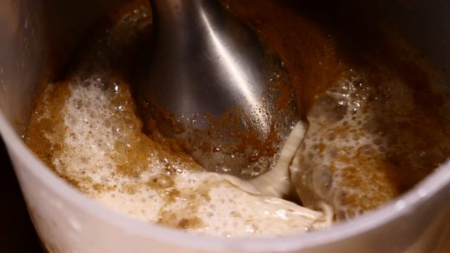 Close-up of mixer whipping milk smoothie with cinnamon, banana and cottage cheese.