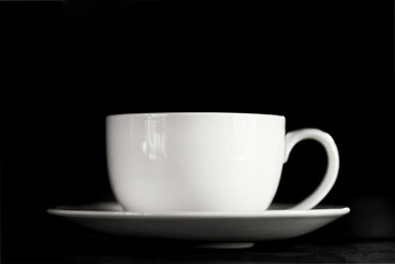 Low key coffee cup isolated on black background.