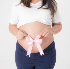 Pregnant woman with pink ribbon on the white