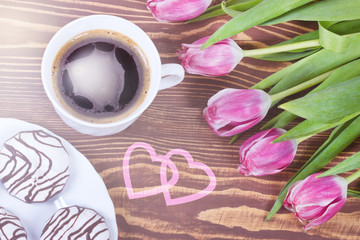Fototapeta na wymiar Cup of coffee,cake and pink tulips on wooden table