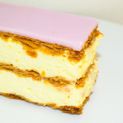 Dessert for a good mood. Slice of puff cake with cream. Selective focus.