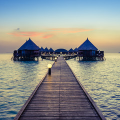 A great vacation on a tropical island. Resort on the tropical islands. Maldives. Bungalows over the water at sunset.