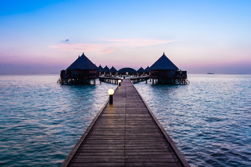 A great vacation on a tropical island. Resort on the tropical islands. Maldives. Bungalows over the water at sunset.