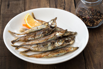 Grilled fish capelin or shishamo on white plate

