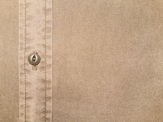 plain beige cotton shirt texture with button in close up