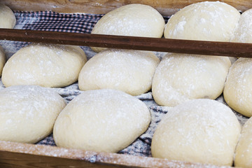 Fototapeta na wymiar bread dough balls fermenting and waiting to put in the oven in a market stall 