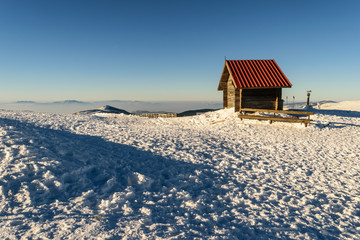 Small log house near ski piste in wintertime on mountain Kopaonik, Serbia