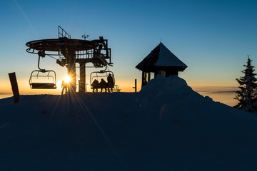 Fototapeta na wymiar Chair ski lift upper end at sunset