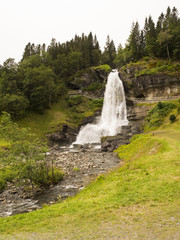 Paisaje  en Norheimsund, norte del Hardangerfjord, donde se ubica la impresionante cascada Steinsdalsfossen, rodeada de vegetaci&oacute;n alpina, Noruega, en el verano de 2017