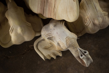 Traditional craftsman carving wood an elephant and sanding wood with motor sandpaper