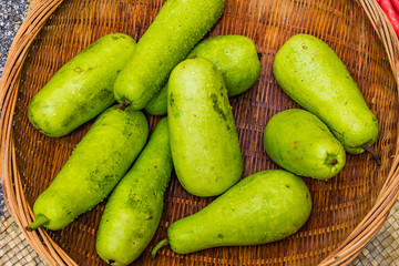 Bunch of fresh green melons in the tray on the wooden table