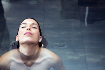 Woman in water with eyes closed