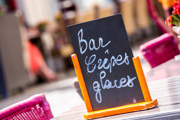 Small black board menu indicating bar, ice-creams and pancakes (