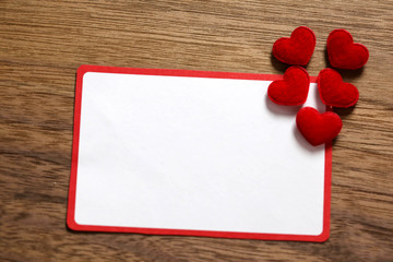 Valentine's day background with love gift, red roses, perfume and heart shapes. View from above. Copy space. Flat lay.