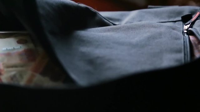 A black bag full of money in Russian currency. Concept on the topic of corruption and impunity of financial crimes in Russia. Russian money in the bag