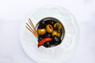 green olives in white bowl on table