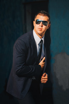 Handsome man in black suit and sunglasses. Secret agent, mafia, bodyguard concept.