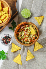 Guacomole is a traditional Mexican sauce consisting of grated avocado, lime juice, red onion, tomatoes, garlic and chili. Served with nachos chips.