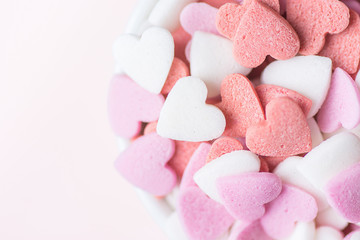 Colorful Pink Red White Sugar Sprinkles Candies in Bowl on White Background. Valentine Romantic Birthday Charity Mother's Day Concept. Greeting Card Poster Copy Space Top View