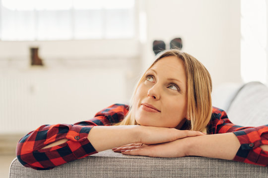 Young woman relaxing on a sofa daydreaming