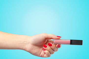 Woman hand holding cosmetic tool isolated on color background