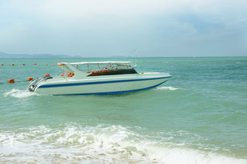 Speed boat parked along the coast, and the back is a mountain and sky