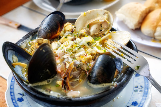 Paila marina served in Santiago de Chile. It is a traditional Chilean seafood soup with shellfish, fish and a variety of herbs and spices such as paprika and parsley.