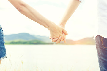 Hands of women lovers holding together between travel in the dam.