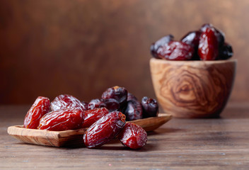 Juicy dates on wooden table .