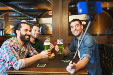 friends taking selfie and drinking beer at bar
