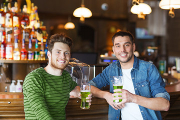 male friends drinking green beer at bar or pub