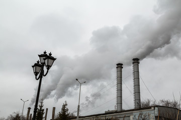 The smoke from the chimneys of the CHP. Pollution of the environment. Environmental disaster.