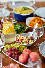 salad, jug of water and other food on wooden table