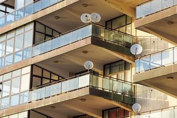 Fototapeta premium Facade of the reseidential building with windows and balconies and satelite antennas