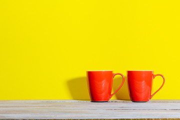 Set of coffee or tea mugs, red on yellow background