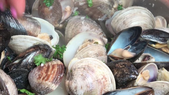 Steamed Clams and Mussels in white wine broth. Garnished with parsley and lemon.