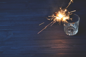 Sparkler in the glass. Holidays lights. New Year celebration. 