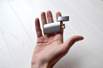 Man holding a usb lighter in his hands. - Powered by Adobe