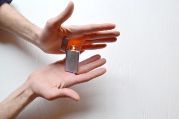 Man holding a usb lighter in his hands.