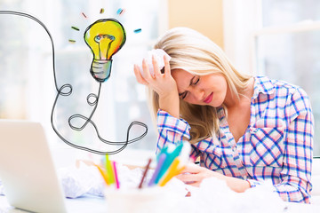 Lightbulb with young woman with crumpled paper balls
