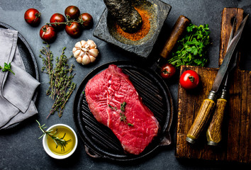 Fresh raw meat steak beef tenderloin, herbs and spices around cutting board. Food cooking...