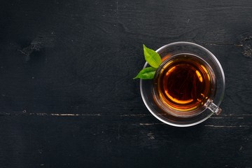 A cup of black tea on a wooden background. Top view. Copy space.
