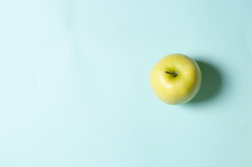 green apple lies on a turquoise background
