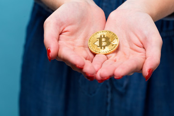 Woman holding a physical bitcoin cryptocurrency in her hands