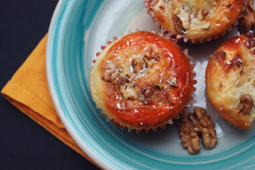 Healthy Homemade Muffins, apple and banana Cakes on a blue rustic plate, Orange Napkins and black background